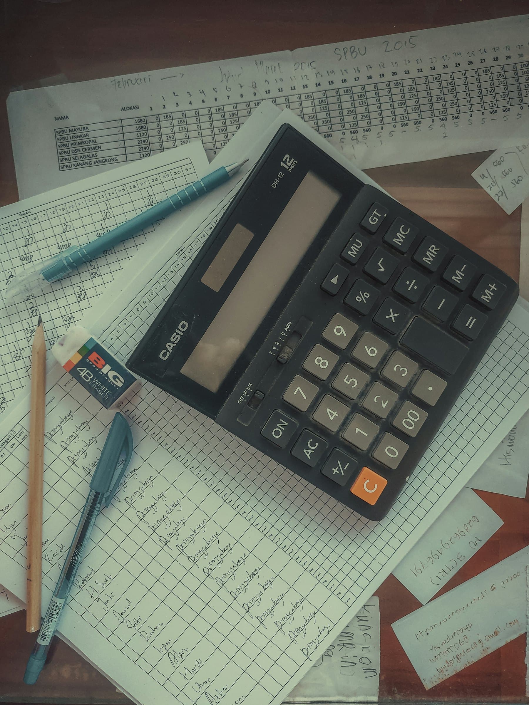 A calculator resting on a stack of printed financial papers